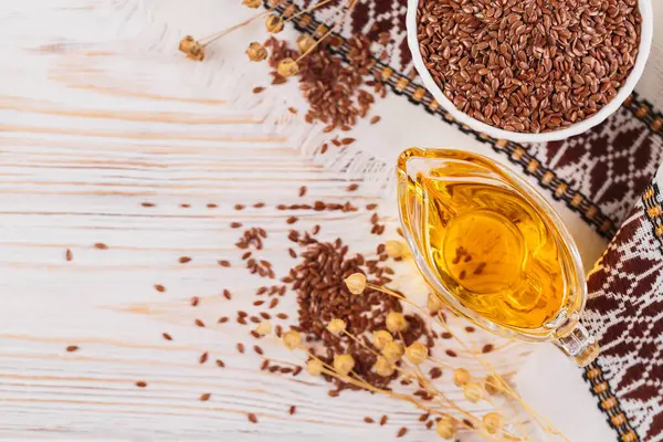 Kahverengi keten tohumu, keten tohumu sebze yağı, beyaz kırsal ahşap arka planda. Sağlıklı süper yiyecek üst görünümü, fotokopi alanı ile düz yatış