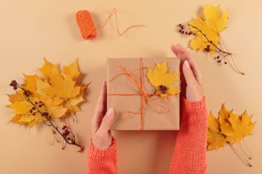 Kurumuş yapraklarla hediyeleri paketleme ve dekore etme süreci. El işi kağıdında hediye kutuları ve doğal sonbahar süslemeleri, yaratıcı ve sıfır atık tatil hediye paketi. DIY kavramı
