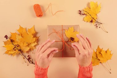 Kurumuş yapraklarla hediyeleri paketleme ve dekore etme süreci. El işi kağıdında hediye kutuları ve doğal sonbahar süslemeleri, yaratıcı ve sıfır atık tatil hediye paketi. DIY kavramı