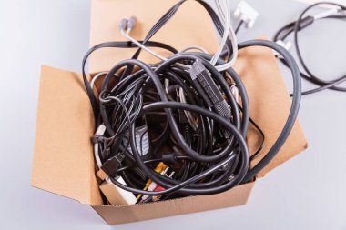 Kullanılmış bilgisayar ekipmanları ve cep telefonlarının mukavva kutuya doldurulması, uygunsuz imha edilmenin ekolojik etkisini vurguluyor.