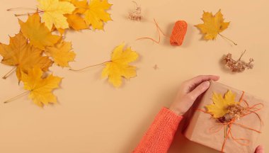 Kurumuş yapraklarla hediyeleri paketleme ve dekore etme süreci. El işi kağıdında hediye kutuları ve doğal sonbahar süslemeleri, yaratıcı ve sıfır atık tatil hediye paketi. DIY kavramı