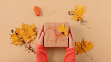 Kurumuş yapraklarla hediyeleri paketleme ve dekore etme süreci. El işi kağıdında hediye kutuları ve doğal sonbahar süslemeleri, yaratıcı ve sıfır atık tatil hediye paketi. DIY kavramı