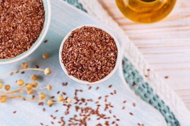 Kahverengi keten tohumu, keten tohumu, beyaz ahşap arka planda sebze yağı. Sağlıklı süper yiyecek üst görünümü, düz yatış