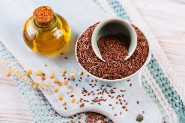 Kahverengi keten tohumu, keten tohumu, beyaz ahşap arka planda sebze yağı. Sağlıklı süper yiyecekler