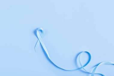 Koyu mavi bir yüzeyde mavi bir kurdele, kolorektal kanseri sembolize ediyor. Temiz ve profesyonel, tıbbi kampanyalar ve savunma projeleri için ideal..