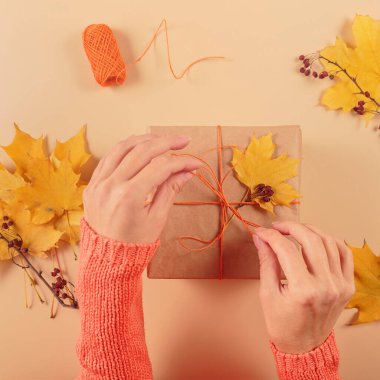 Kurumuş yapraklarla hediyeleri paketleme ve dekore etme süreci. El işi kağıdında hediye kutuları ve doğal sonbahar süslemeleri, yaratıcı ve sıfır atık tatil hediye paketi. DIY kavramı