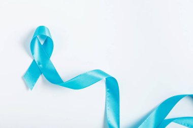 A blue ribbon folded neatly on a white surface, representing colorectal cancer awareness. Minimalist design, perfect for medical brochures and educational content. clipart