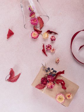 Hediye paketleme ve süsleme işlemi kurumuş çiçeklerle yapılır. El işi kağıdında hediye kutuları ve doğal sonbahar süslemeleri, yaratıcı ve sıfır atık tatil hediye paketi. DIY kavramı