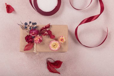 Hediye paketleme ve süsleme işlemi kurumuş çiçeklerle yapılır. El işi kağıdında hediye kutuları ve doğal sonbahar süslemeleri, yaratıcı ve sıfır atık tatil hediye paketi. DIY kavramı