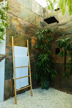 Yeşillik ve doğal dokuları olan kaplıca gibi bir banyo.