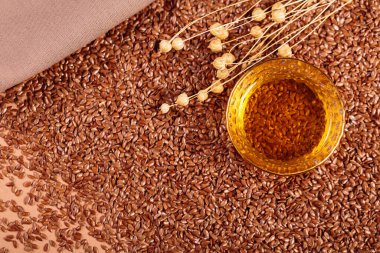 Kahverengi keten tohumu, bej arka planda keten tohumu bitkisi yağı. Keten tohumu geçmişi. Sağlıklı süper yiyecek üst görünümü, fotokopi alanı ile düz yatış