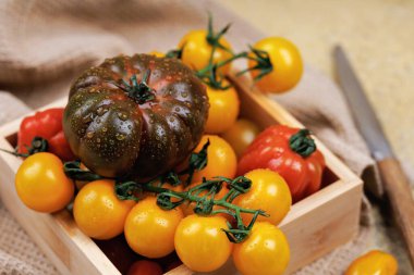 Ahşap kutuda aile yadigarı ve sarı domatesler.