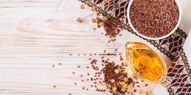 Kahverengi keten tohumu, keten tohumu sebze yağı, beyaz kırsal ahşap arka planda. Sağlıklı süper yiyecek afişi, üst görünüm, fotokopi alanı ile düz uzanma