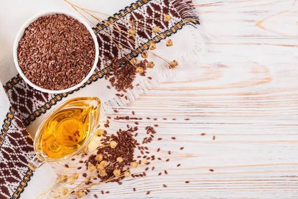 Kahverengi keten tohumu, keten tohumu sebze yağı, beyaz kırsal ahşap arka planda. Sağlıklı süper yiyecek üst görünümü, fotokopi alanı ile düz yatış