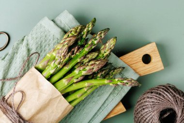 Ahşap tahta ve yeşil havluya sarılı kuşkonmaz.