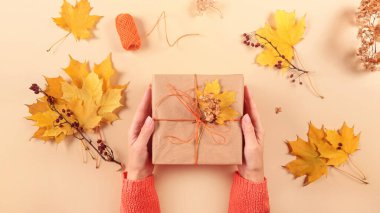 Kurumuş yapraklarla hediyeleri paketleme ve dekore etme süreci. El işi kağıdında hediye kutuları ve doğal sonbahar süslemeleri, yaratıcı ve sıfır atık tatil hediye paketi. DIY kavramı