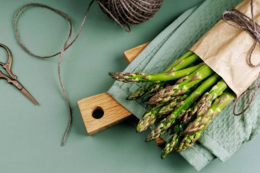 Tahtayı sicim ve makasla kesen taze kuşkonmazın üst görüntüsü