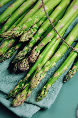 Mutfak havlusuna sarılı taze kuşkonmaz. Yukarıdan fotokopi aletiyle çekilmiş.