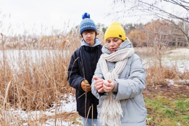 Soğuk bir kış gününde dışarıda kartopu oynayan anne ve oğul doğal ortamdaki ortak aktivitelere odaklandılar.