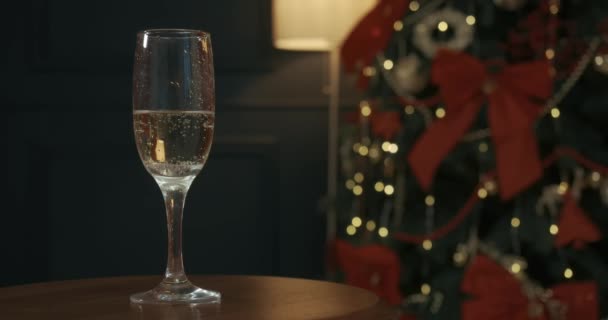 Szklanka Szampana Wino Musujące Stojące Stoliku Obok Ozdobionej Choinki Ludzie — Wideo stockowe