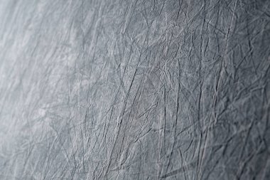 Kırışık beyaz kumaşın soyut gri arka plan tasarımı, grunge. Kabataslak desen arkaplanının bir tarafı açık, diğer tarafı koyu renkli, tek renkli. Arkaplan ve doku kavramı.