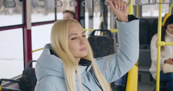 乘客等候 公共汽车在车站弯下腰 金发迷人的漂亮姑娘坐上大巴 握住手 向前看 现代生活和日常城市生活的概念 — 图库视频影像
