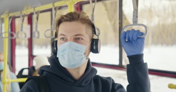Вид Спереди Наушниками Медицинской Маске Перчатках Пассажир Стоящий Автобусе Слушающий — стоковое видео