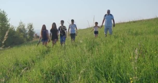 Widok Przodu Starca Dziećmi Idącymi Przodu Chodzącymi Wysokiej Trawie Mówiącymi — Wideo stockowe