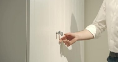 Beyaz gömlek ve kot pantolon giyen, beyaz gardırop açan, gösteren, temsil eden bir satıcı. Mobilya dükkanında çalışan, satış yapan bir adam. Kentsel yaşam tarzı kavramı. 