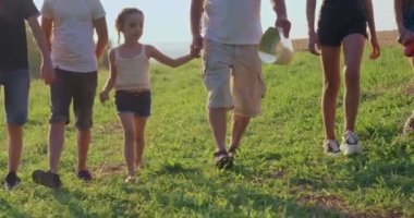 Elinde çocukların ilerlediği yeşil çimenlerde yürüyüp eğlenen yaşlı bir adam haritası olan bir yere. Turistler tepelerde birlikte geziyor, yürüyüş yapıyorlar. Destek ve dostluk kavramı.