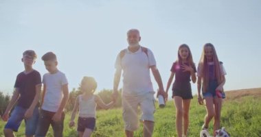 Çocukların ilerleyişini, Jack Russell Terrier ve ihtiyarla yürümesini, harita göstermesini, arama güzergahını. Tepelerde seyahat eden turistler. Doğayı keşfeden kavram.