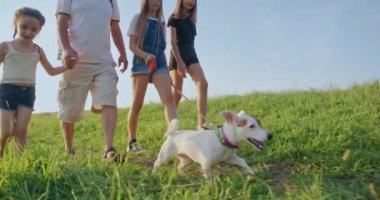 Tepelerde yürüyen, Jack Russel Terrier 'a önderlik eden, yaşlı bir adamla ilerleyen bir grup çocuk. Birlikte seyahat eden turistler. Destek ve dostluk kavramı.