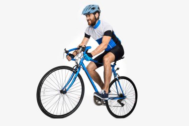 Bearded caucasian cyclist wearing sports equipment, riding bike. Side view of male cyclist making effort to ride fast, isolated on white studio background. Concept of sport lifestyle, action, motion. clipart