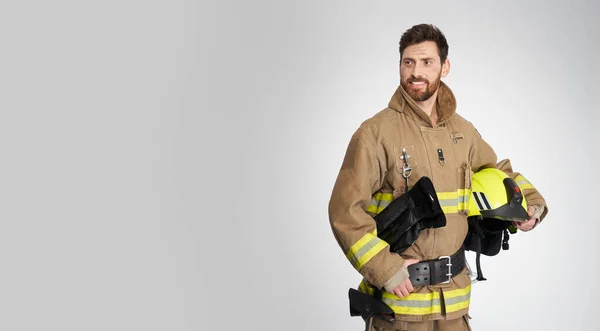 Uśmiechnięty Strażak Pozujący Trzymając Się Pas Studio Portret Atrakcyjnego Strażaka — Zdjęcie stockowe