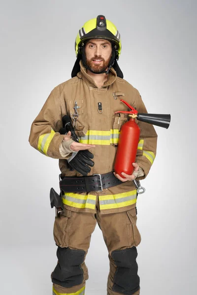 Handsome Firefighter Presenting Fire Extinguisher Studio Portrait Smiling Bearded Man — Stock Photo, Image
