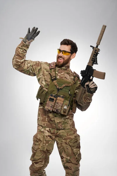 Boldog Álruhás Fegyveres Férfi Integet Valakinek Stúdióban Vidám Katona Taktikai — Stock Fotó