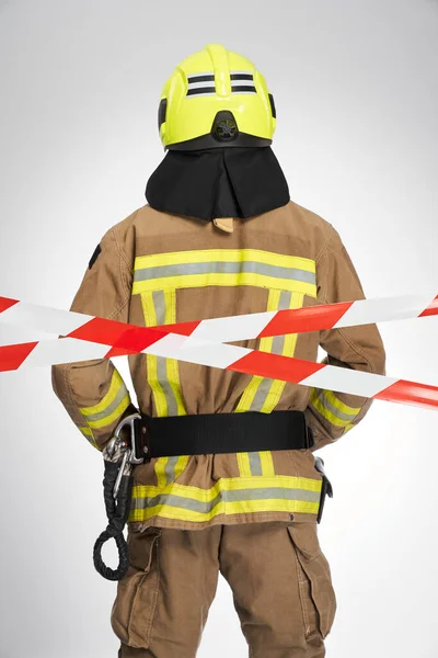 Strong Unrecognizable Firefighter Helmet Standing Red White Caution Tape Back — Stock Photo, Image