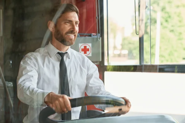 Gledelig Mannlig Sjåfør Som Ser Fremover Mens Kjører Offentlig Transport – stockfoto