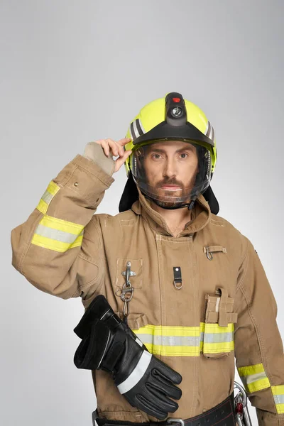 Przystojny Strażak Mundurze Zakładający Kask Ochronny Domu Portret Brodatego Strażaka — Zdjęcie stockowe