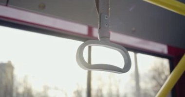 Gri saplı ve durması zor otobüsü kapatın. Tutmak için kulp kullanan yolcular, dengeyi korumak, arka planda akşam kenti. Toplu taşıma ve trafik kavramı.