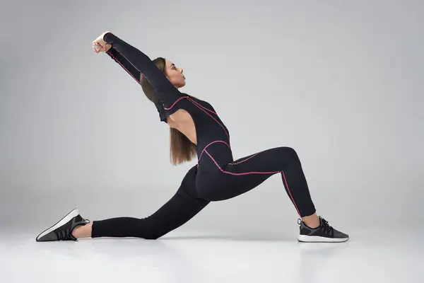 Wanita Fleksibel Dalam Pakaian Hitam Melakukan Pose Warrior Yoga Terhadap — Stok Foto
