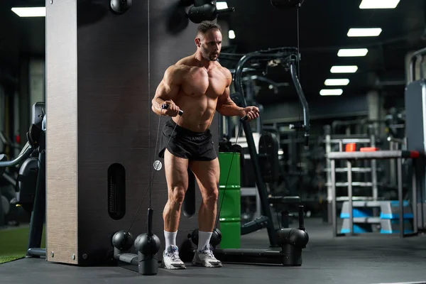 屋内クロスオーバーマシンでの中年コーカサス強力なトレーニング プルダウンを行う筋肉男性アスリートの全長 ジムでケーブルトレーニング装置の持ち上げ重量 クロスフィットコンセプト ストック写真