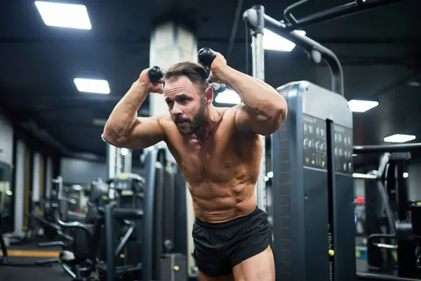 Junger Bärtiger Mann Mit Kräftigem Bauch Gewichte Ziehen Training Fitnessstudio lizenzfreie Stockbilder