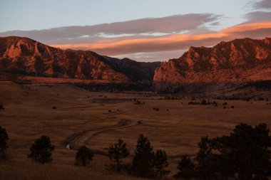 Colorado 'daki El Dorado Kanyonu' na doğru bir yol eserken turuncu gün doğumu kaya oluşumlarında parlıyor.