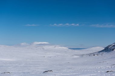 İsveç 'in Jmtland' daki karla kaplı arazisinin üzerinde dalga şeklinde küçük bir bulut yığını.. 
