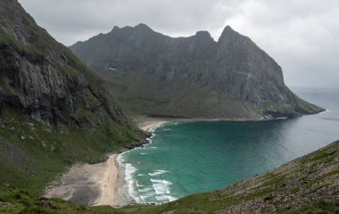 Lofoten 'de yağmurlu bir yaz gününde Kvalvika sahilini gösteren bir hava manzarası.
