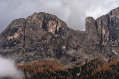 Dolomite dağlarında Corvara 'nın üzerindeki yüksek kireçtaşı uçurumlarının üzerinde kara bulutlarla kaplı bir manzara.
