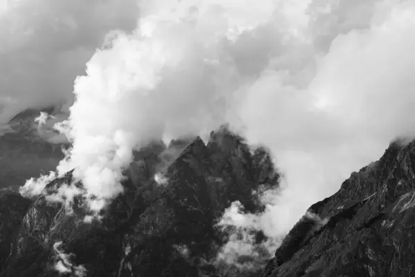 Slovenya 'nın Triglav Ulusal Parkı' ndaki dramatik bir dağ manzarasında bulutlar yükseliyor. Siyah ve Beyaz.