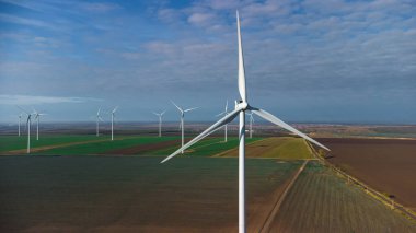 Rüzgâr türbinleri insansız hava aracının bakış açısından sahada duruyor.