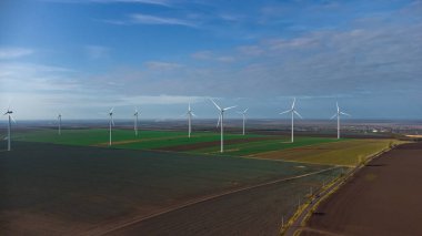 Rüzgâr türbinleri insansız hava aracının bakış açısından sahada duruyor.